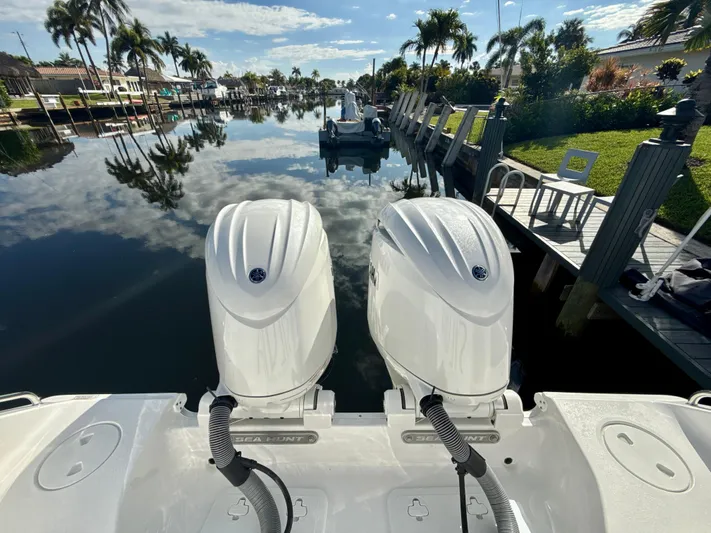  Yacht Photos Pics 2024 Sea Hunt Ultra 275 SE boat with dual engines docked in a scenic canal.