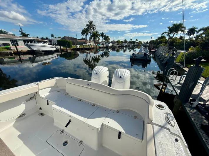  Yacht Photos Pics 2024 Sea Hunt Ultra 275 SE boat docked by a serene waterfront with palm trees.