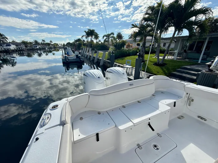  Yacht Photos Pics 2024 Sea Hunt Ultra 275 SE boat docked by a serene waterfront with palm trees.