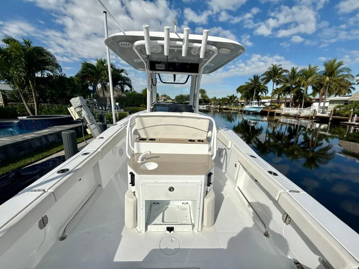  Yacht Photos Pics 2024 Sea Hunt Ultra 275 SE boat docked by a scenic canal with palm trees.