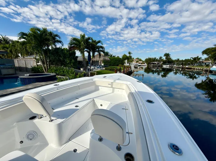  Yacht Photos Pics 2024 Sea Hunt Ultra 275 SE boat on a calm waterway with palm trees.