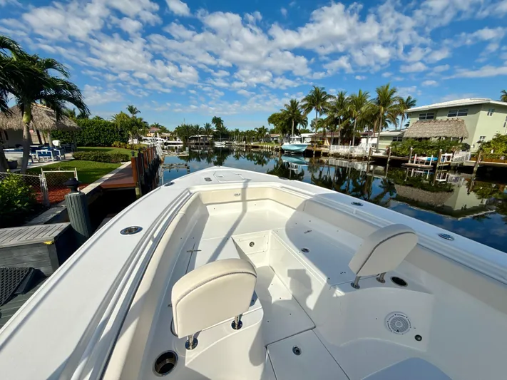  Yacht Photos Pics 2024 Sea Hunt Ultra 275 SE boat docked in a scenic canal with palm trees.