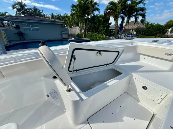  Yacht Photos Pics 2024 Sea Hunt Ultra 275 SE boat with open storage compartment, poolside setting.