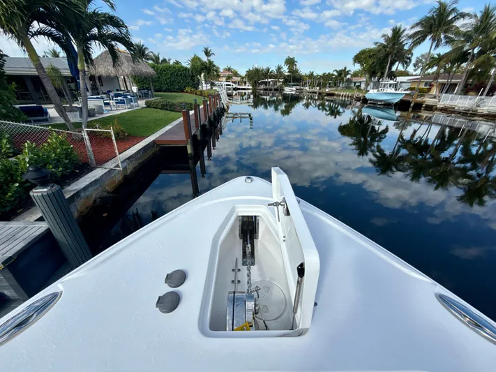  Yacht Photos Pics 2024 Sea Hunt Ultra 275 SE boat on a calm canal with palm trees.