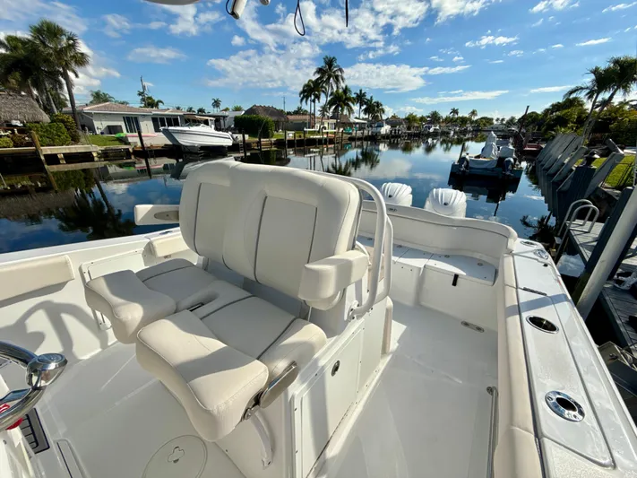  Yacht Photos Pics 2024 Sea Hunt Ultra 275 SE boat with luxurious seating, docked in a scenic canal.