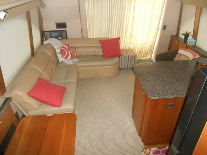  Yacht Photos Pics Interior of 2004 Meridian 540 Pilothouse with beige sofa, red pillows, and kitchenette.