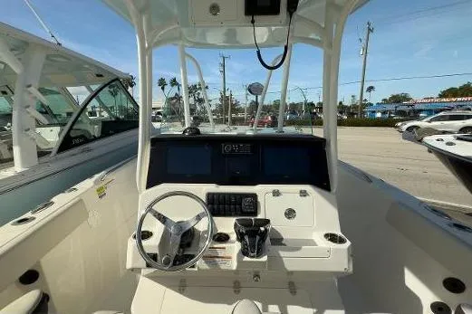 242-934 Yacht Photos Pics 2024 Sailfish 242 CC boat cockpit with steering wheel and control panel.