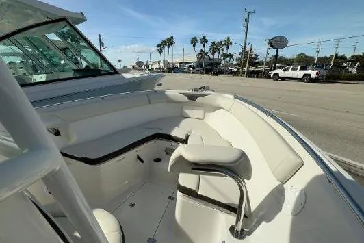 242-934 Yacht Photos Pics 2024 Sailfish 242 CC boat interior with seating, parked near a road with palm trees.