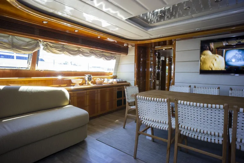 Paladin Yacht Photos Pics Luxurious interior of 2000 Ferretti Yachts Custom Line 94 with dining area and sofa.