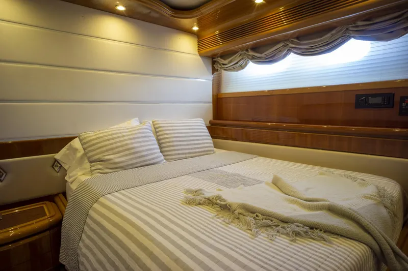 Paladin Yacht Photos Pics Luxurious bedroom interior on 2000 Ferretti Yachts Custom Line 94, featuring elegant wood finishes.