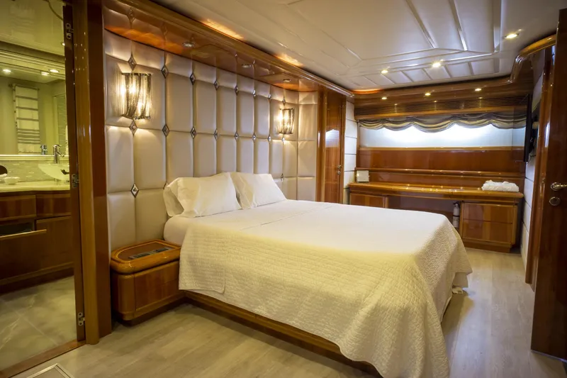 Paladin Yacht Photos Pics Luxurious bedroom interior of 2000 Ferretti Yachts Custom Line 94 with elegant wood finishes.