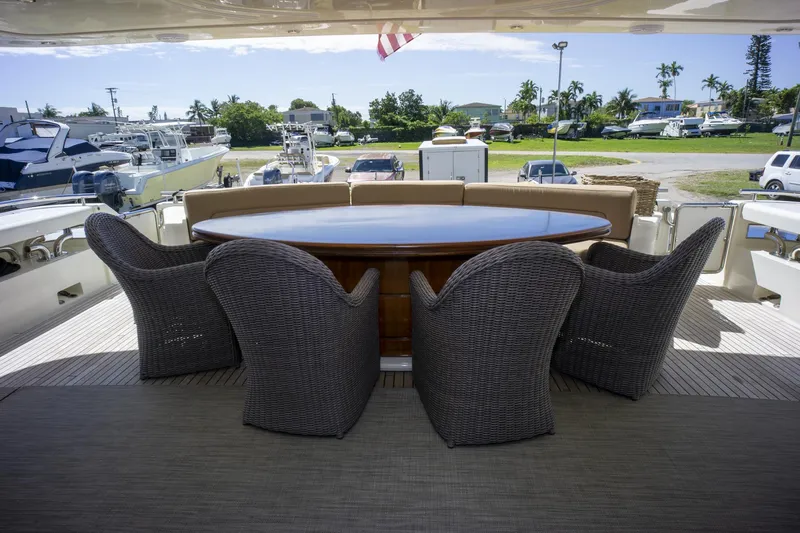 Paladin Yacht Photos Pics Outdoor dining area on 2000 Ferretti Yachts Custom Line 94, featuring wicker chairs and oval table.