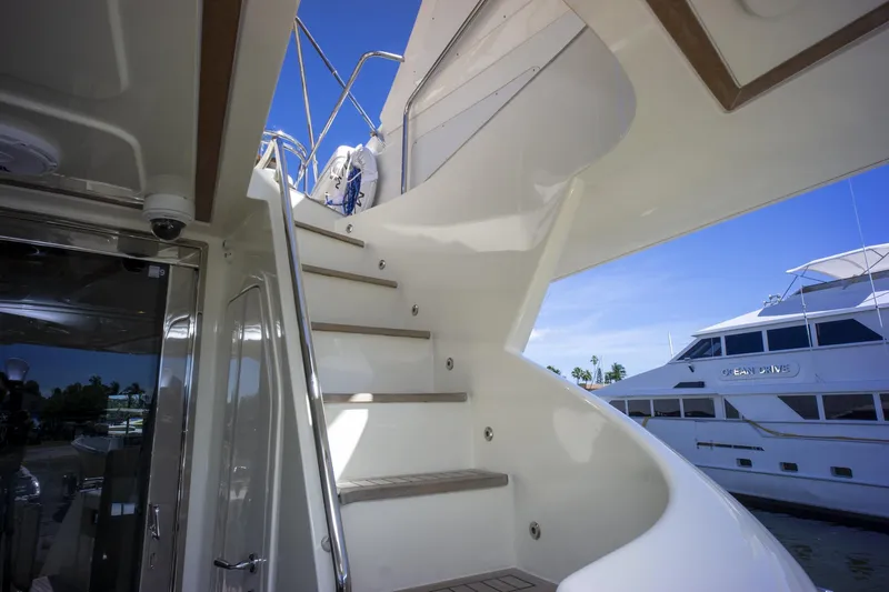 Paladin Yacht Photos Pics Curved staircase on 2000 Ferretti Yachts Custom Line 94, docked with another yacht nearby.