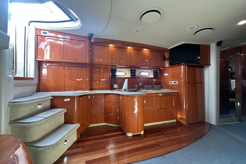 Navion Yacht Photos Pics Luxurious interior of 2001 Sea Ray 510 Sundancer yacht with polished wood cabinetry and modern amenities.
