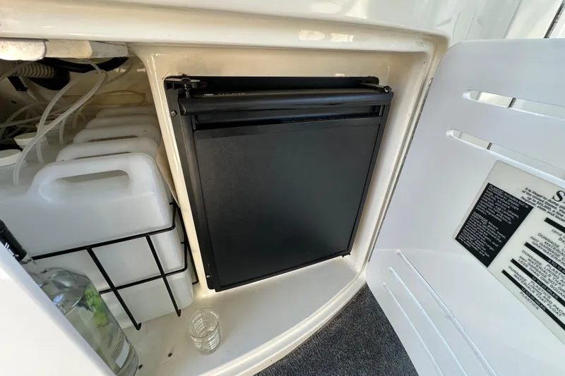 Navion Yacht Photos Pics 2001 Sea Ray 510 Sundancer storage compartment with containers and a small refrigerator.
