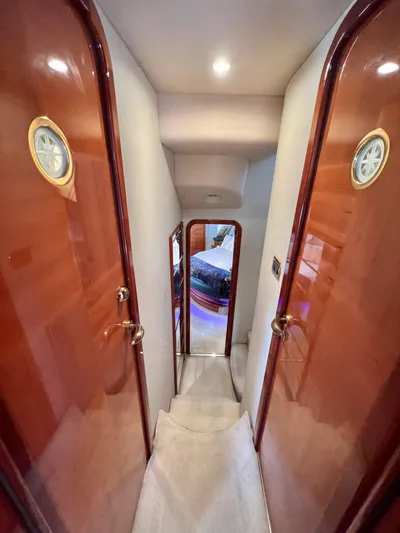 Bad Decisions Yacht Photos Pics Interior hallway of a 2004 Azimut 55E yacht with wooden doors and elegant lighting.