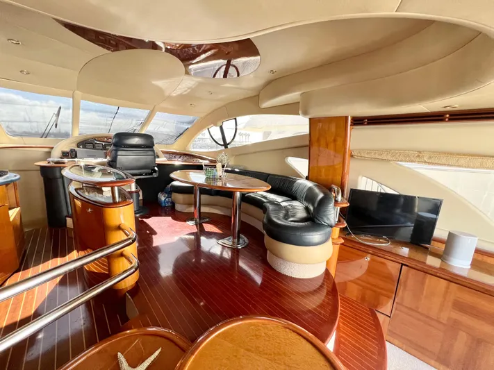 Bad Decisions Yacht Photos Pics Luxurious interior of a 2004 Azimut 55E yacht with elegant seating and wooden finishes.