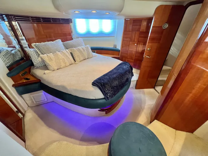 Bad Decisions Yacht Photos Pics Luxurious bedroom interior of 2004 Azimut 55E yacht with elegant wood finishes and ambient lighting.