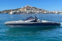2008 SACS Strider boat cruising near a coastal city with a historic hilltop view.