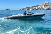 2008 SACS Strider boat cruising near a coastal town with lighthouse and clear blue waters.