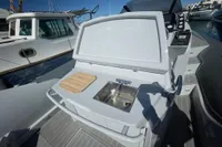 2008 SACS Strider boat with outdoor sink and cutting board on deck.