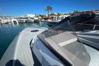 Luxury SACS Strider 2008 yacht docked in a sunny marina, showcasing sleek design and spacious deck.