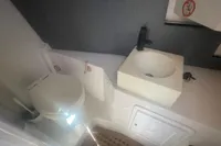 Compact bathroom in 2008 SACS Strider boat with toilet and modern sink.