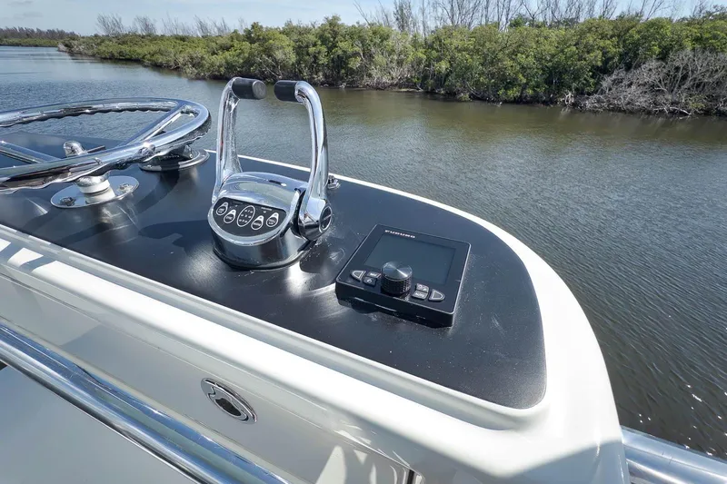 Sparkle Plenty Yacht Photos Pics 2009 Gamefisherman Express boat helm with controls and navigation system on a calm river.