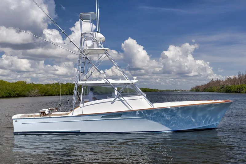 Sparkle Plenty Yacht Photos Pics 2009 Gamefisherman Express boat on calm water under a blue sky with clouds.