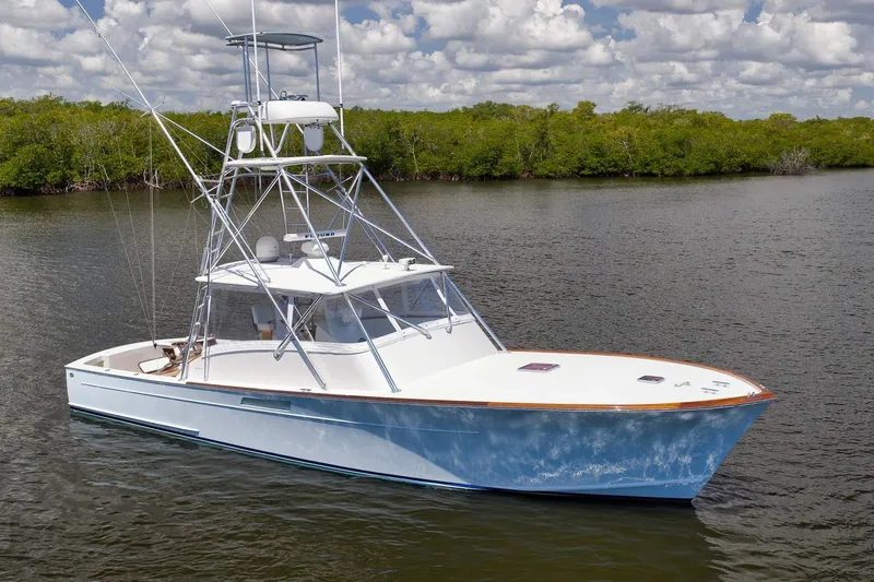 Sparkle Plenty Yacht Photos Pics 2009 Gamefisherman Express boat on calm water with lush green shoreline.