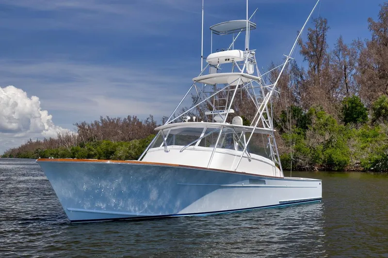 Sparkle Plenty Yacht Photos Pics 2009 Gamefisherman Express boat on calm water, surrounded by lush greenery and clear skies.