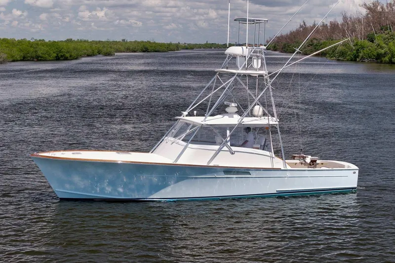 Sparkle Plenty Yacht Photos Pics 2009 Gamefisherman Express boat on a calm river, surrounded by lush greenery.