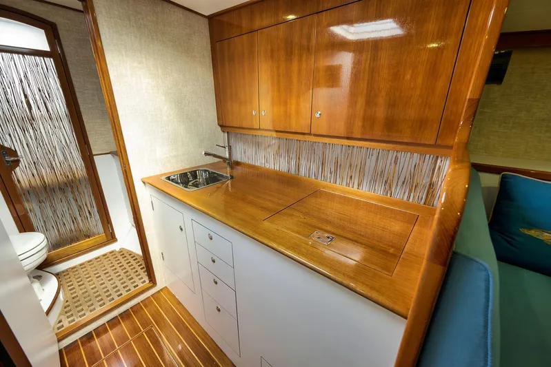 Sparkle Plenty Yacht Photos Pics Luxurious 2009 Gamefisherman Express yacht interior with wooden cabinetry and compact kitchen area.