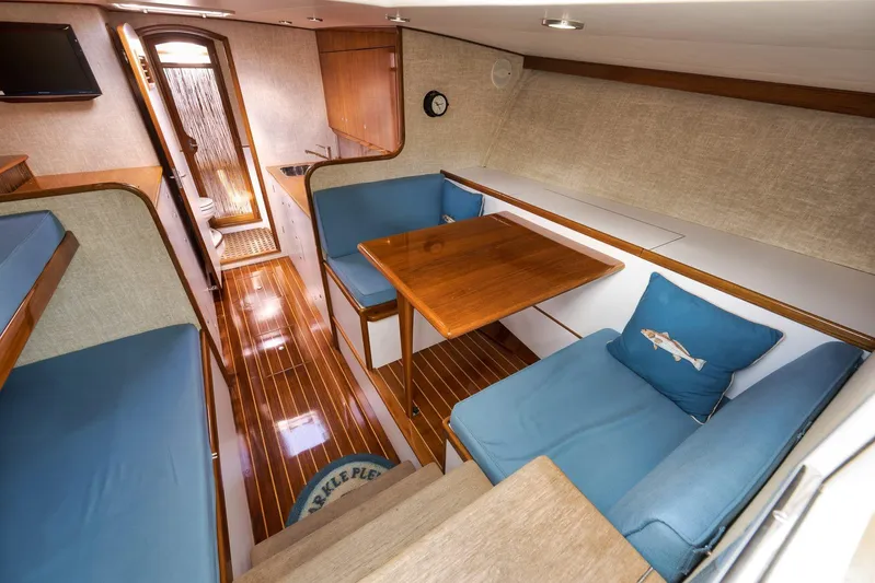 Sparkle Plenty Yacht Photos Pics Luxurious 2009 Gamefisherman Express interior with wooden flooring, blue seating, and a compact dining area.