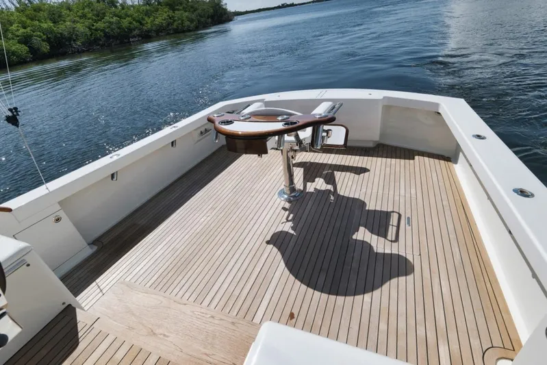 Sparkle Plenty Yacht Photos Pics 2009 Gamefisherman Express boat deck with fishing chair, surrounded by calm waters and lush greenery.