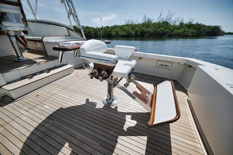Sparkle Plenty Yacht Photos Pics 2009 Gamefisherman Express boat deck with fishing chair, wooden flooring, and scenic water view.
