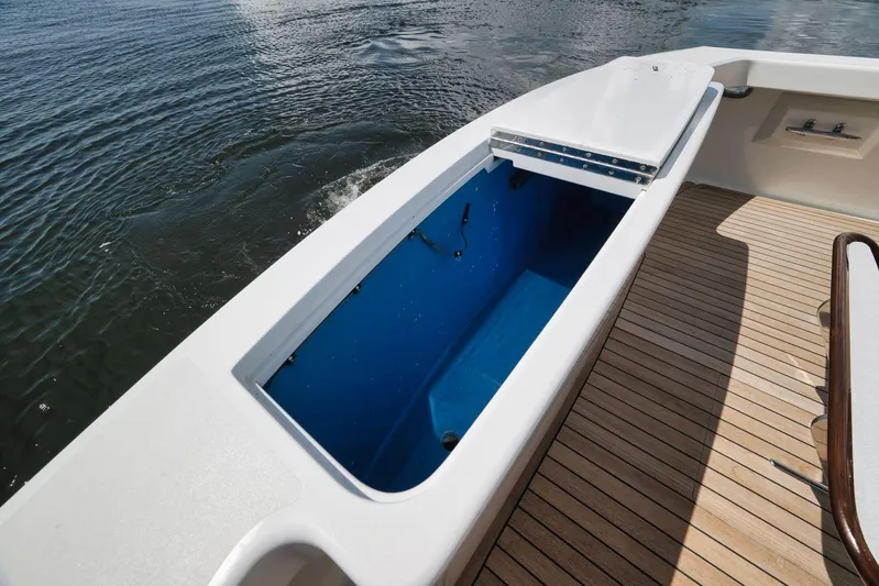 Sparkle Plenty Yacht Photos Pics 2009 Gamefisherman Express boat with open storage compartment and teak deck on water.