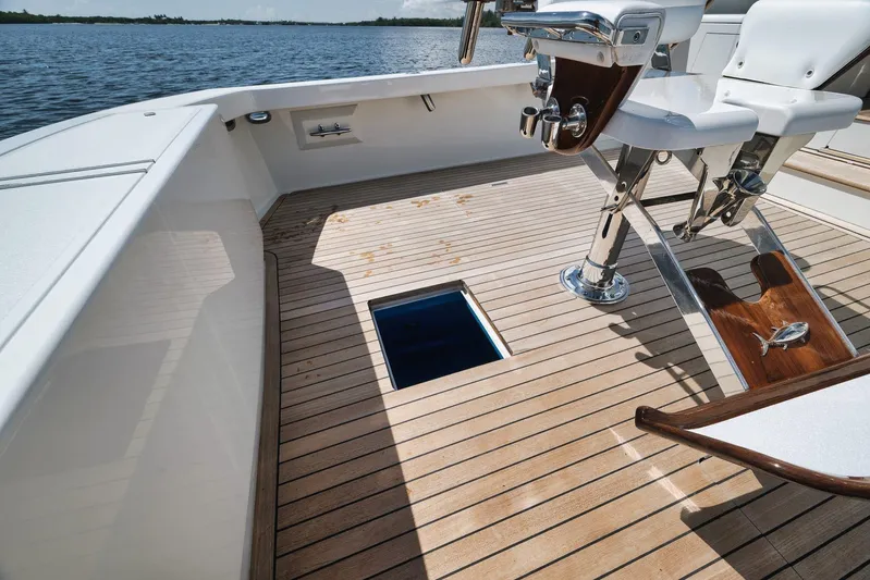 Sparkle Plenty Yacht Photos Pics 2009 Gamefisherman Express boat deck with fishing chair and open hatch, overlooking water.