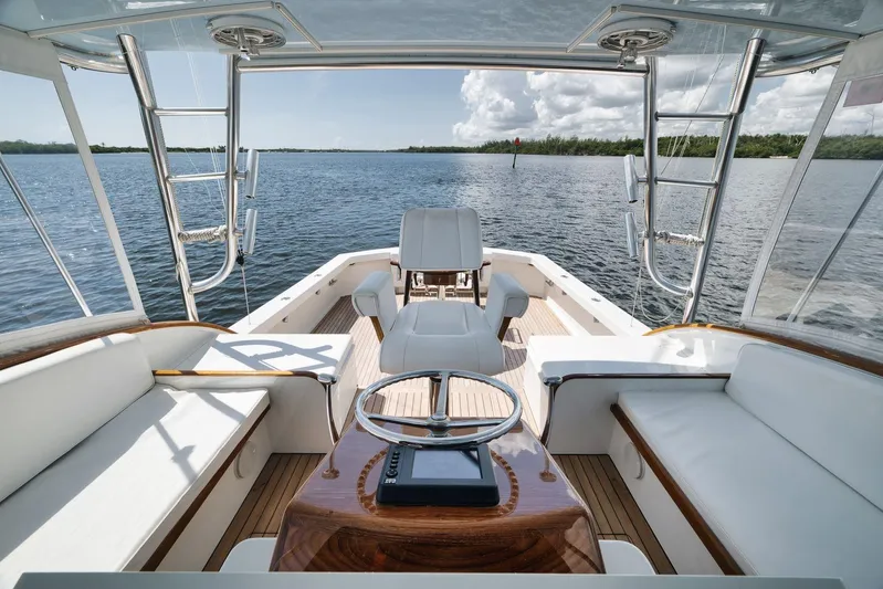 Sparkle Plenty Yacht Photos Pics 2009 Gamefisherman Express boat interior with luxurious seating and steering wheel, overlooking calm waters.