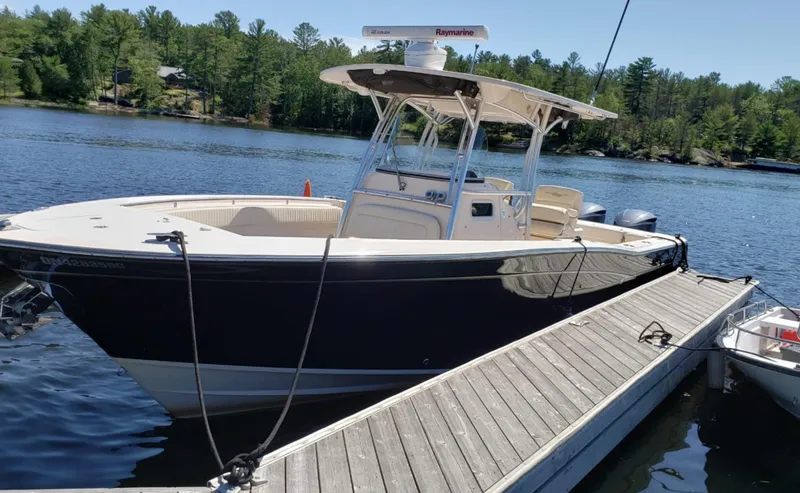  Yacht Photos Pics 2014 Grady-White Canyon 306 boat docked on a serene lake with forested background.