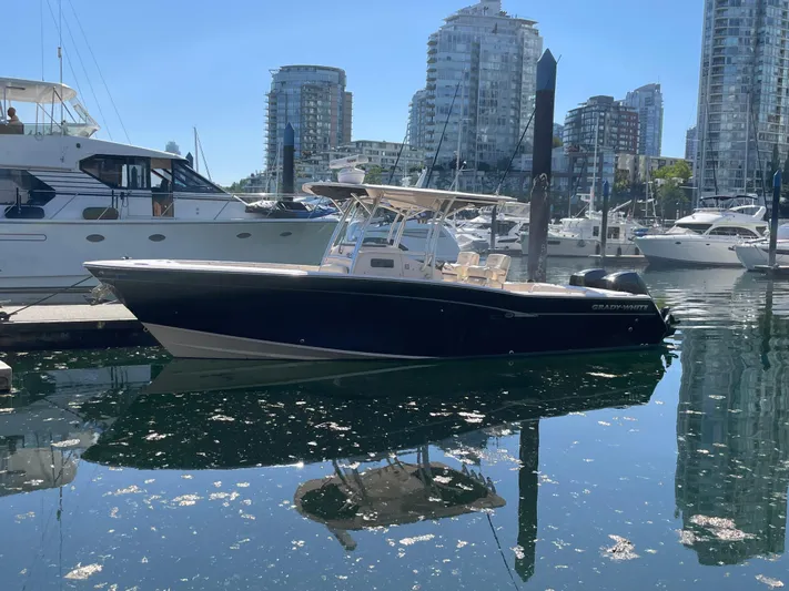  Yacht Photos Pics 2014 Grady-White Canyon 306 boat docked in a marina with cityscape background.