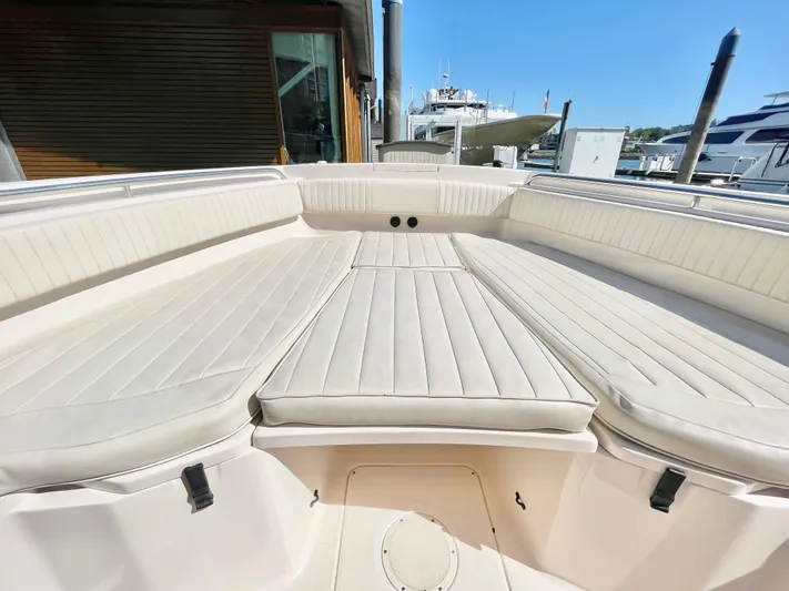  Yacht Photos Pics 2014 Grady-White Canyon 306 boat interior with cushioned seating at a marina.