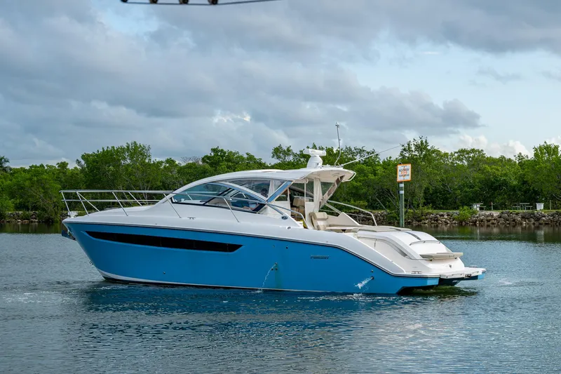  Yacht Photos Pics 2018 Pursuit SC 365i Sport Coupe cruising on a calm lake under cloudy skies.
