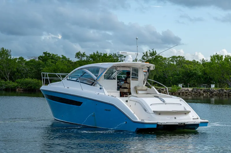  Yacht Photos Pics 2018 Pursuit SC 365i Sport Coupe cruising on a serene waterway.