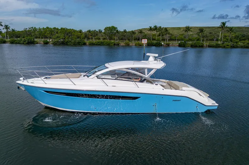  Yacht Photos Pics 2018 Pursuit SC 365i Sport Coupe cruising on a serene lake with lush greenery.