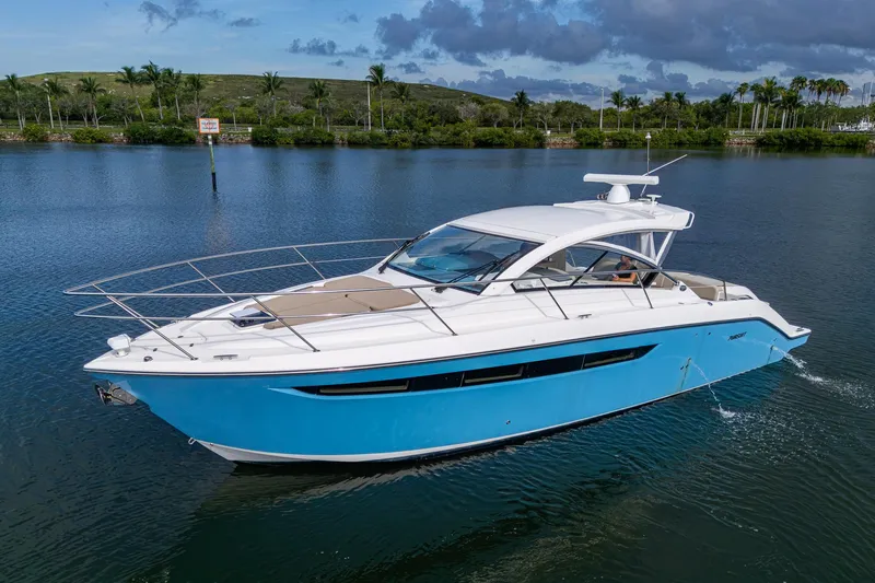  Yacht Photos Pics 2018 Pursuit SC 365i Sport Coupe cruising on a serene lake with lush greenery.