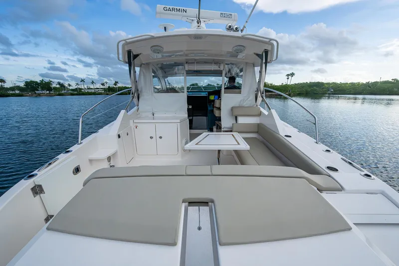  Yacht Photos Pics 2018 Pursuit SC 365i Sport Coupe on calm water, featuring spacious deck and seating.