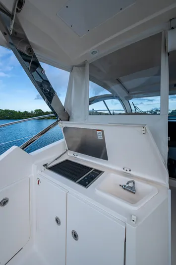  Yacht Photos Pics 2018 Pursuit SC 365i Sport Coupe boat interior with sink and grill, overlooking water.