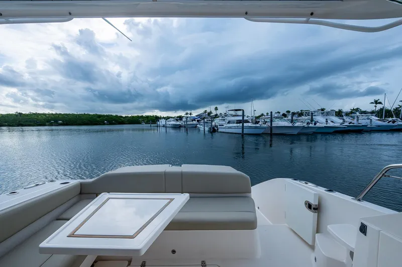  Yacht Photos Pics 2018 Pursuit SC 365i Sport Coupe overlooking marina with cloudy sky.