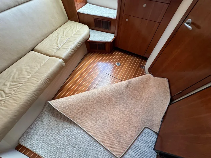  Yacht Photos Pics Interior of 2011 Rampage 34 IPS boat with wooden flooring and beige seating.